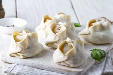 Raw frozen manti on a board