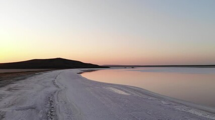Aerial view Tilted downward shot Pink Salt Lake low key. Cinematic film grain. Evening shot