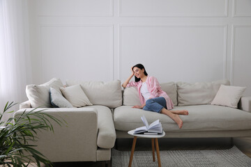 Woman resting on sofa in living room