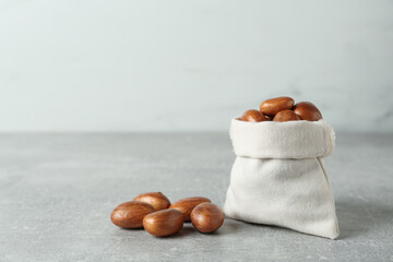 Sackcloth bag with jackfruit seeds on light grey table. Space for text