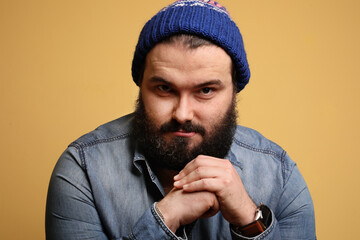 Portrait of handsome man with beard, posing over yellow background. Isolated.