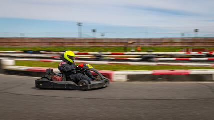 Fototapeta premium A panning shot of a racing kart as it circuits a track.