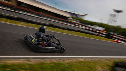 Obraz premium A panning shot of a racing kart as it circuits a track.