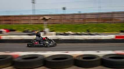A panning shot of a racing kart as it circuits a track.