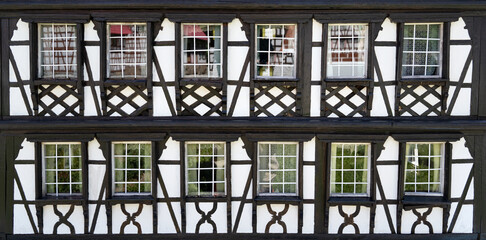 Fassade Detail von einem  Modellbau Fachwerkhaus mit zwei Reihen Fenstern mit Spiegelungen in den...