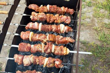 Marinated shashlik preparing on a barbecue grill over charcoal. Shashlik or Shish kebab popular in Eastern Europe. Shashlyk (skewered meat) was originally made of lamb. Roast Beef Kebabs On BBQ Grill.
