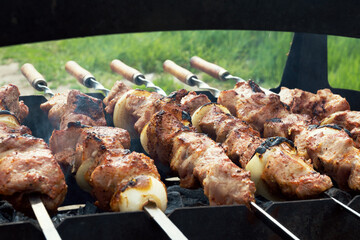 Marinated shashlik preparing on a barbecue grill over charcoal. Selective focus. Shashlyk (skewered meat) was originally made of lamb. Roast Beef Kebabs On BBQ Grill.