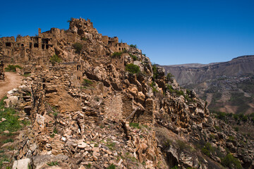 Fototapeta na wymiar  The ghost village of Gamsutl is the oldest settlement in the Republic of Dagestan. It is unique for its unusual architecture, similar to the city of Machu Picchu in Peru. At the moment it is abandone