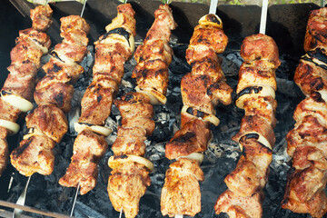 Marinated shashlik preparing on a barbecue grill over charcoal. Shashlik or Shish kebab popular in Eastern Europe. Shashlyk (skewered meat) was originally made of lamb. Roast Beef Kebabs On BBQ Grill.