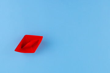 red paper boat on a blue background