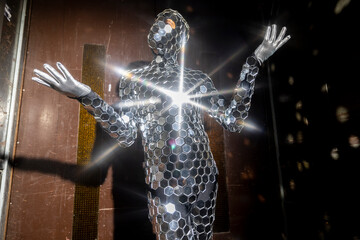 Sparkling discosuit man dancing in a lift