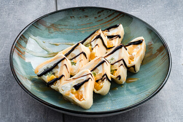 Sweet sushi roll on white plate with mascarpone cheese