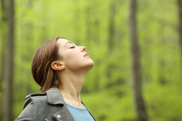 Woman breathing fresh air deeply in a forest