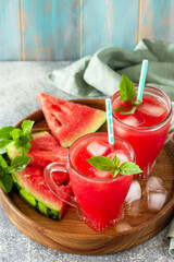 Summer cold drink. Refreshing Watermelon drink in glasses and slices of watermelon on a stone tabletop.