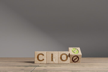 Wood cubes with acronym 'CIO' - 'Chief Information Officer' on a beautiful wooden table, studio background. Business concept and copy space.