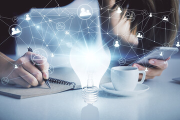 Double exposure of light bulb hologram and woman holding and using a mobile device. Idea concept.