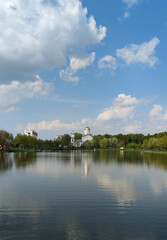 Scenic view of a park with a reservoir in the center of a big city in spring. A pond in the park in the middle of green trees. Rest in the city, oasis.