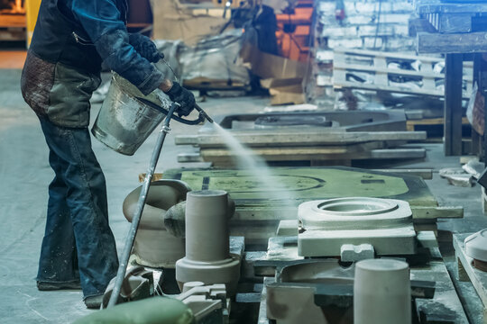 Woman Worker Sprays Special Molds For Smelting Metal Parts In Foundry Workshop.