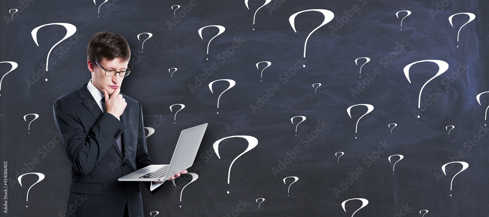Aufkleber thinking concept with pensive businessman with laptop on chalkboard background with question marks.
