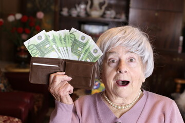Surprised senior woman with full wallet 