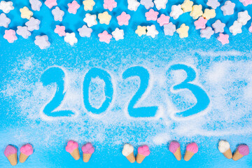 text 2023 is written on a sugar candy background. new year concept
