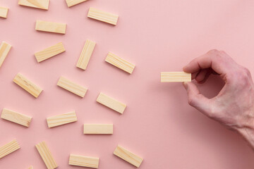 Hand choosing a wooden block from a large group. Business choice concept