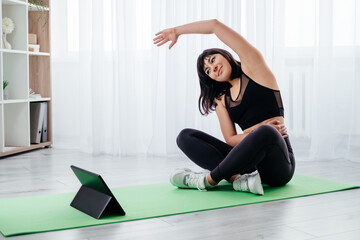Online sport. Female fitness. Home training. Healthy body. Happy athletic woman in black sportswear...