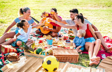 Multiracial families having fun together with kids at pic nic barbecue party - Joy and love life style concept with mixed race people toasting juices with children at park - 434089697