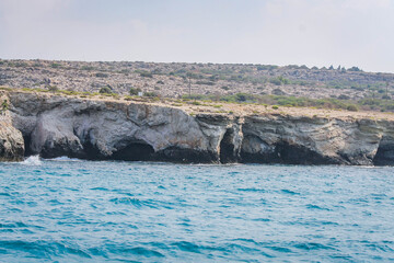 Fototapeta premium Small backwater surrounded by a stone cliff with azure water in Cyprus