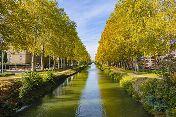 Beautiful autumn views of Canal du Midi (in XVII century - Royal Canal in Languedoc) in Toulouse and trees reflection in water. Toulouse, Haute-Garonne, France.