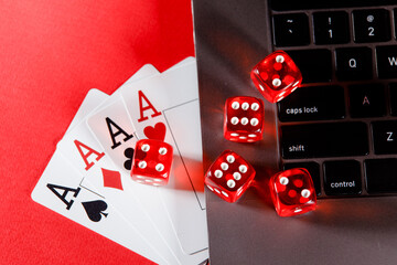 Online poker concept. Playing cards and dices on a red background