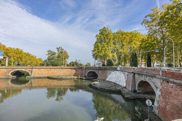Fototapeta premium Beautiful autumn views of Canal du Midi (in XVII century - Royal Canal in Languedoc) in Toulouse and trees reflection in water. Toulouse, Haute-Garonne, France.