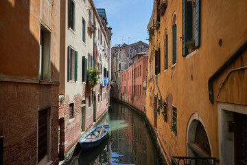 Small canal with orange walls in Venice, Italy