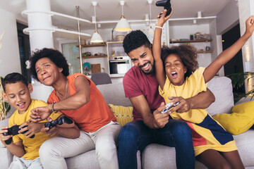 African American family playing video games together and having fun at home