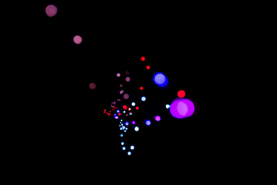 Bokeh of small colored lights in the dark in the shape of an enneagon