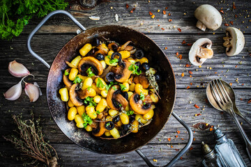 Gnocchi with fried white mushrooms on wooden table
