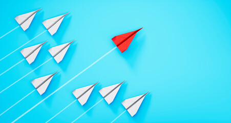 Group of paper airplanes with red leader plane on blue background
