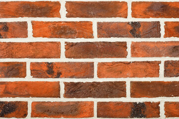 The texture and background of the wall with a decorative finish imitating a brown brickwork surface.