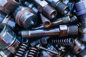 Steel mechanical parts smeared with machine oil, close-up. Steel nozzles, springs, studs, couplings and tubes.