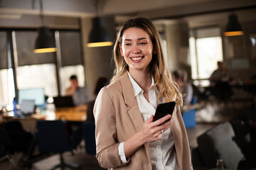 Businesswoman in office. Smiling beautiful businesswoman using the phone.
