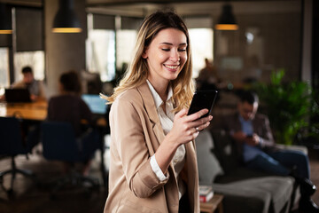 Businesswoman in office. Smiling beautiful businesswoman using the phone.