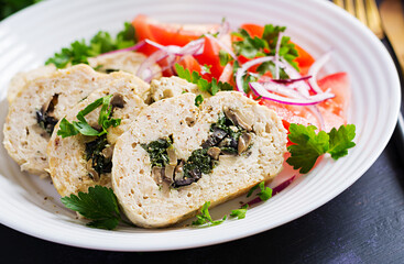 Meatloaf roll stuffed with spinach, olives, mushrooms and tomatoes salad. Diet menu.
