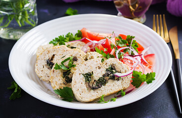 Meatloaf roll stuffed with spinach, olives, mushrooms and tomatoes salad. Diet menu.