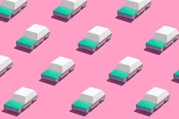 Minimal retro future car concept pattern wtih teal green cars on bright vibrant neon pink background. Trendy bold summer travel and road trip idea. Retro aesthetic.