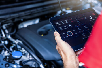 car service mechanic using digital tablet with diagnostics software to check engine condition....