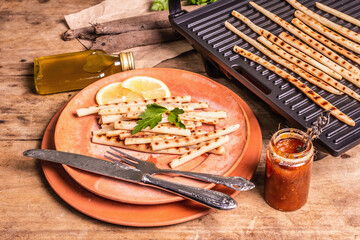 Grilled scorzonera with sauce on old wooden table