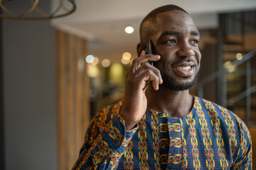 Black african businessman wearing traditional clothing, mobile phone