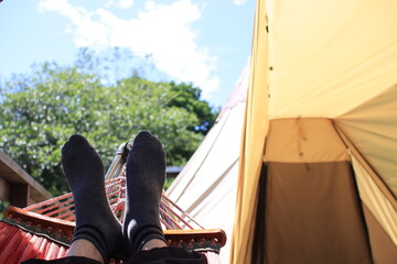 People relaxing in hammock at camp