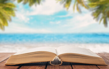 Open book on the table against the background of the sea (ocean)