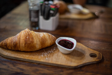 Croissant isolated on table with jam on the side